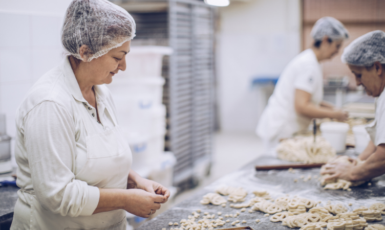 3 mulheres trabalhando na produção de biscoitos 