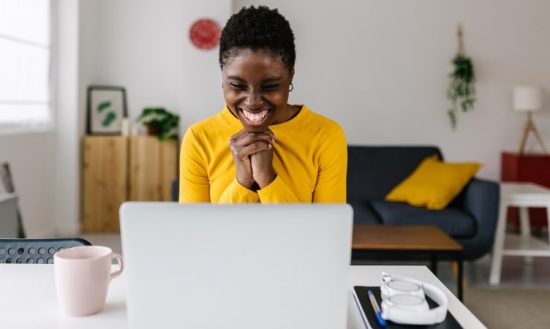 mulher feliz olhando para notebook - sucesso nos negócios