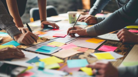 Imagem de pessoas em uma mesa com post its