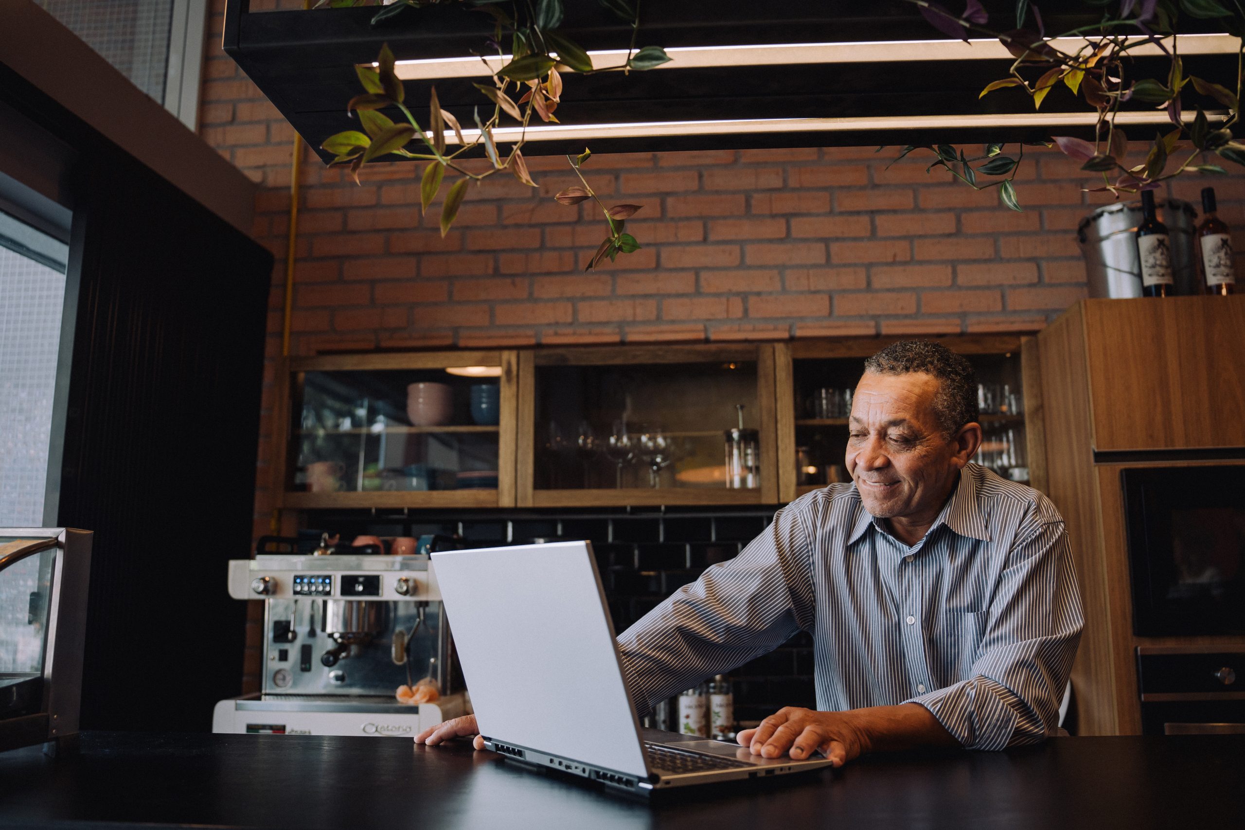A imagem contém um homem mexendo em um notebook.