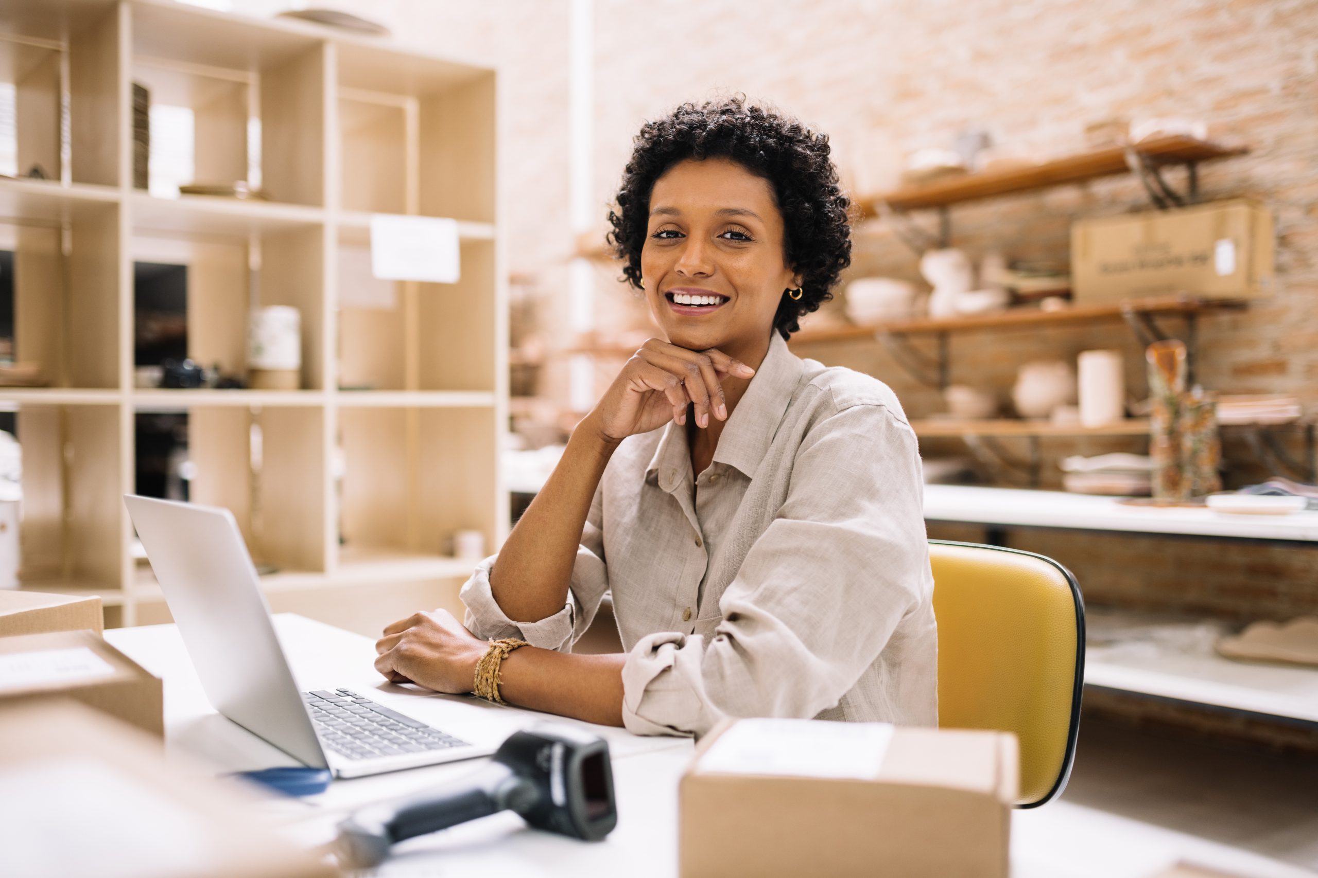 Imagem do blog Reforma Tributária para MEI. Mulher em seu ambiente de trabalho sentada em frente ao computador. 
