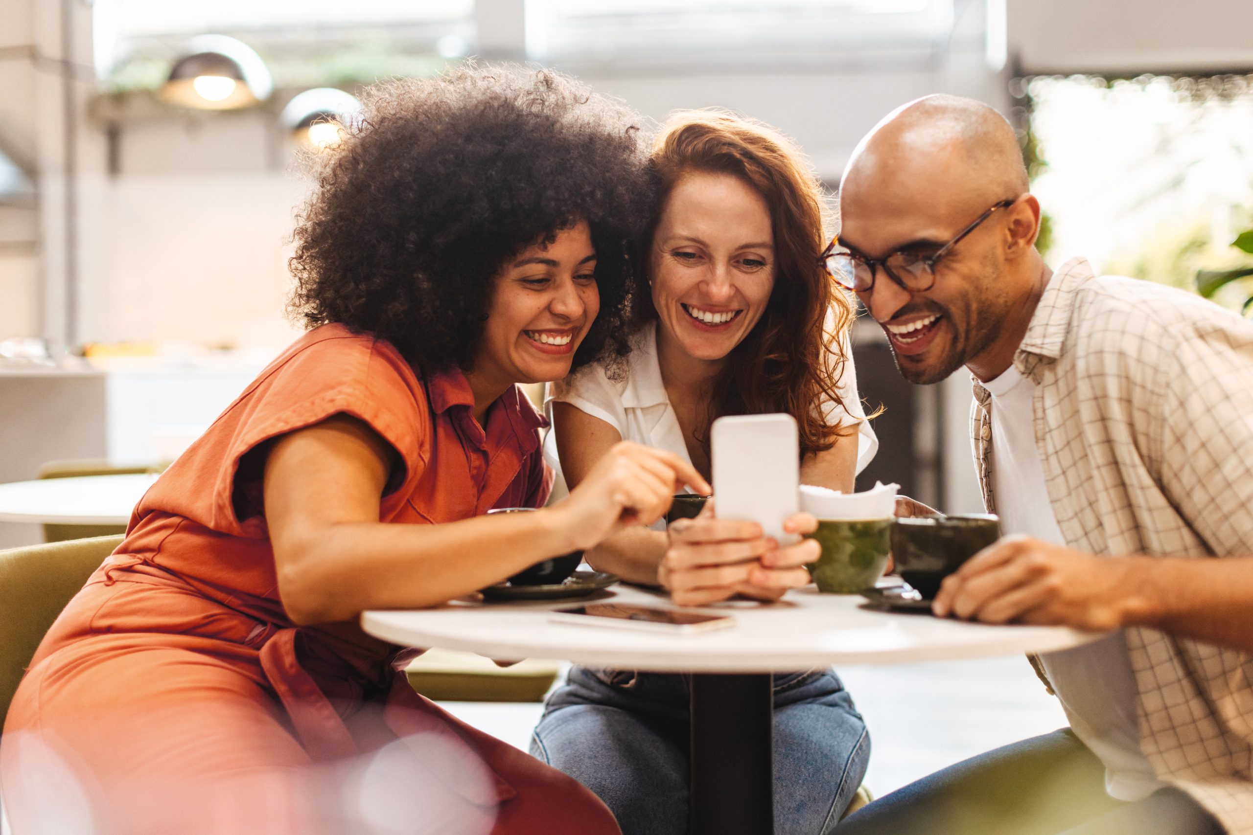 Imagem blog Marketing de Comunidade. Clientes conversam reunidos em um pequeno café, em clima de encontro e proximidade.