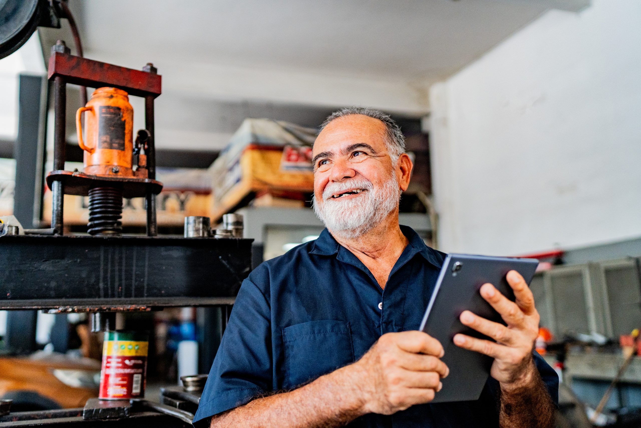 Imagem blogpost NFS-e Nacional. Homem numa oficina com tablet na mão